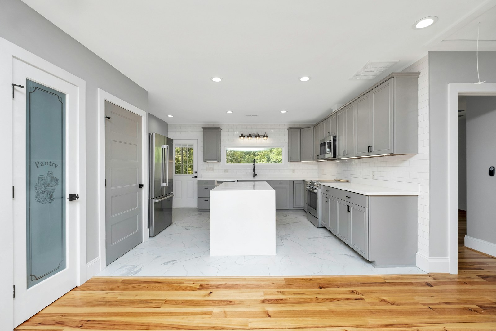 Remodeled kitchen with shaker cabinets, an island, and stainless steel appliances